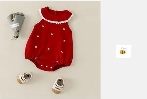 Détail de la barboteuse rouge pour bébé avec col en dentelle blanche et motifs nœuds