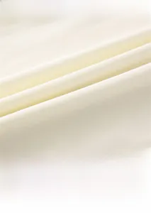 Détail du tissu en maille de coton doux et de l'encolure de l'ensemble bébé beige