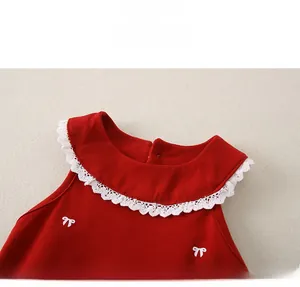 Détail du haut rouge bébé fille avec dentelle blanche et broderie nœud au col