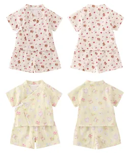 Détail de pyjamas en gaze pour bébé avec fermeture à nouer et motifs ours et lapin