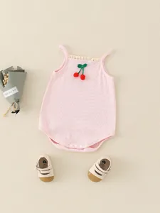 Rosa Baby-Body aus Baumwolle mit Kirschstickerei und beigen Schuhen auf cleanem Grund