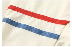 Detail of boys cotton shirt showing cream waffle fabric texture and red blue decorative tape