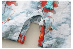 Detail of baby romper featuring blue cloud patterns and secure snap button closures