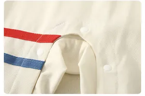 Detail shot of baby romper snap buttons with red and blue stripes on piqué cotton fabric
