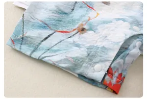Detail of baby romper featuring Chinese ink style floral prints and resin snap buttons