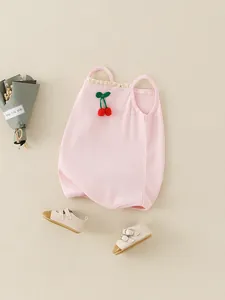 Rosa gerippter Baby-Strampler mit Kirschstickerei und Spitzenträgern auf beigem Hintergrund