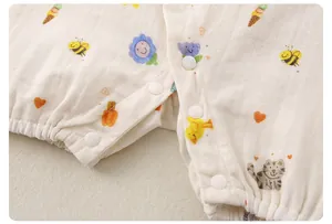 Detail of breathable cotton gauze baby bodysuit featuring colorful cartoon prints and snaps