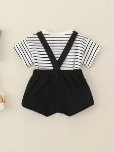 Platliggende baby zomersethand met zwart-wit gestreept shirt en zwarte korte bretelsbroek