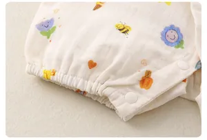 Macro detail of breathable muslin baby romper fabric with cute cartoon prints and snap buttons
