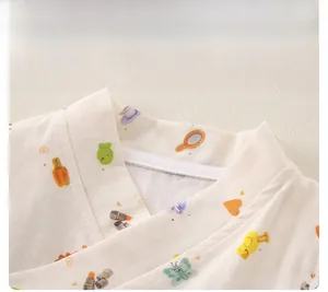 Détail du col d'un pyjama en gaze de coton pour bébé avec motifs oiseaux et papillons colorés