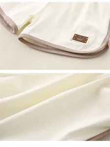 Détail du short en coton crème pour bébé avec liseré marron et étiquette tissée Ook!