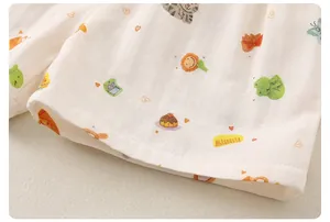 Détail du pyjama bébé montrant la gaze de coton double couche et les motifs cartoon