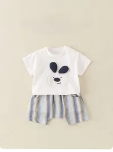 Ensemble d'été bébé en coton avec broderie chien et short rayé posé à plat