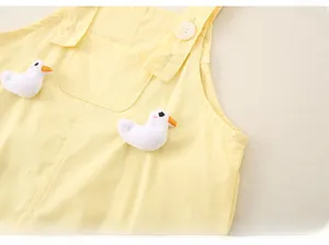 Détail d'une barboteuse jaune pour bébé avec peluches canards 3D et boutons blancs