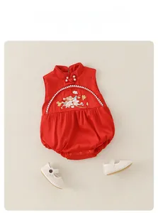 Detail of red sleeveless baby romper with traditional knots and floral embroidery
