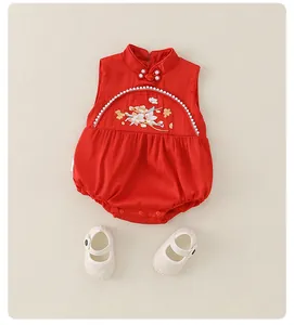 Detail of red New Chinese style baby romper with floral embroidery and white infant shoes