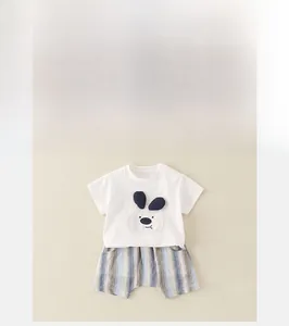 Détail d'ensemble été bébé avec t-shirt blanc, patch chien 3D et short en coton rayé