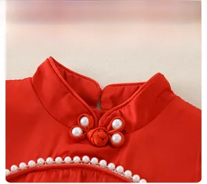 Detail of red satin romper with mandarin collar, traditional knot and pearl embellishments