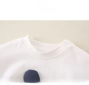 Gros plan détaillé du col rond côtelé sur un t-shirt en coton blanc pour les jeunes enfants