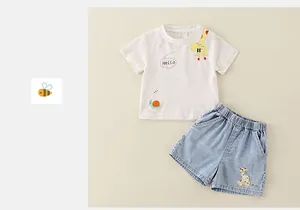Detail of white cotton baby t-shirt with cartoon giraffe print and denim shorts