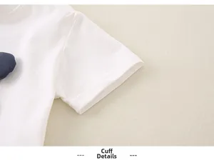 Détails de la couture double sur le revers de la manche d'un t-shirt blanc en coton enfant