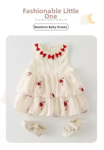 Détail du barboteuse nouveau-né avec nœuds rouges et broderies florales sur tulle
