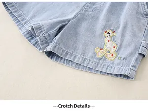 Detail of light blue denim shorts with a colorful cartoon giraffe embroidery for toddlers