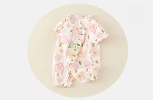 Dettaglio di un body floreale per neonati con colletto a balze e fiocchi decorativi