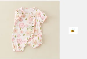 Dettaglio della tutina per neonata con motivo floreale rosa e bordo in pizzo fine
