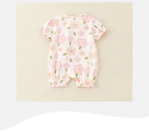 Dettaglio di una tutina estiva bianca per neonata con motivi floreali rosa e volant