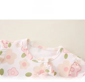 Dettaglio del colletto a fiori per neonata con volant rosa e fiocco dolce