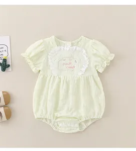 Dettaglio di pagliaccetto per neonati con ricamo nuvola rosa e pizzo bianco verde chiaro