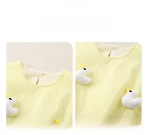 Detailed macro view of the yellow cotton baby dress with cute 3D duckling decoration