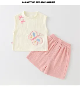 Detail van babymeisjes zomersset van ademend katoenen gaas met fijne vlinderborduurwerk