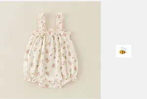 Detail of baby floral romper featuring ruffled shoulder straps and snap button closure