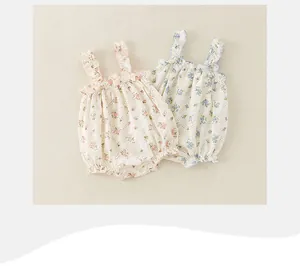 Flat lay detail of floral baby rompers with ruffled straps in pink and blue cotton