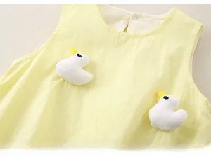 Close-up of baby bodysuit with 3D white plush ducklings on yellow cotton fabric