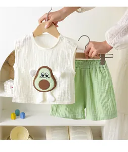 Detail van witte mousseline mouwloze top en groene shorts met avocado-applicatie