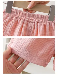 Detail van de roze katoenen gaasshorts met elastische taille en fijne stikseltextuur