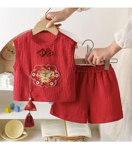 Close-up of traditional red cotton baby suit with gold dragon embroidery and tassels