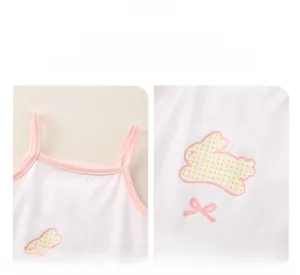 Dettaglio del body neonato rosa con trama in cotone, applique a coniglio e fiocco