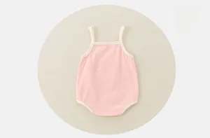 Dettaglio di un body per neonato in cotone rosa con spalline e bottoni automatici
