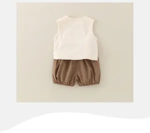 Detail of baby boy cotton summer set featuring cream vest and brown bloomers