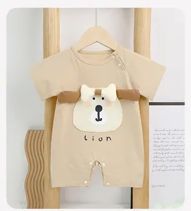 Detail of baby cotton romper featuring 3D animal ears and cute lion print on khaki fabric