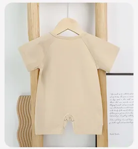 Detail view of baby short sleeve cotton romper in beige with smooth back raglan sleeves