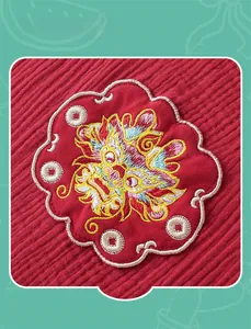 Détail de la broderie de dragon mignon sur la barboteuse d'été en coton rouge gaufré