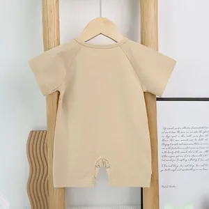 Short sleeve khaki cotton baby romper hanging on a wooden rack for summer wear