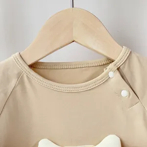 Short sleeve beige baby bodysuit made of pure cotton with side neck buttons for easy dressing