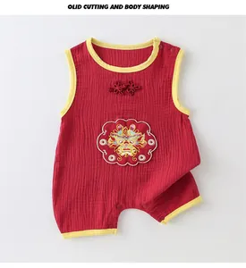 Détail du barboteuse bébé rouge avec broderie dragon dorée et boutons chinois traditionnels