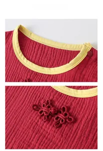 Détail de la barboteuse rouge pour bébé avec passepoil jaune et bouton de nœud chinois